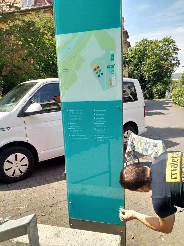 Monteur bei der Montage einer Werbeanlage